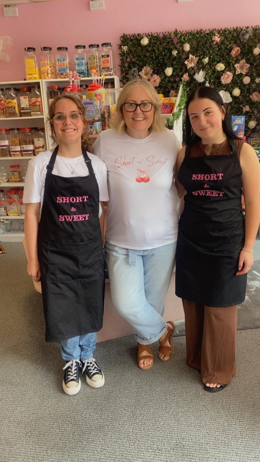 Sue and the Short & Sweet team in black branded aprons inside the pink shop